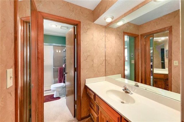 bathroom with toilet, a shower stall, and vanity