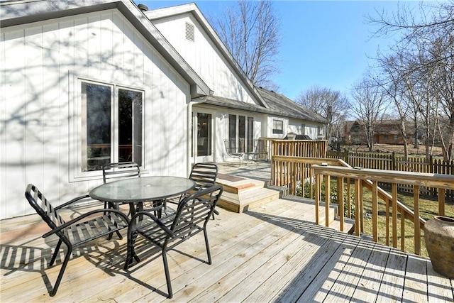 wooden deck with outdoor dining area and fence