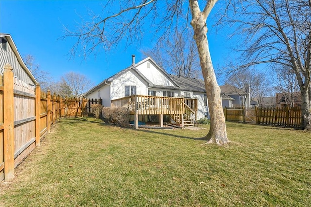 back of property with a fenced backyard, a yard, and a wooden deck