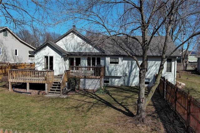 rear view of house with a deck, a shingled roof, a lawn, and a fenced backyard