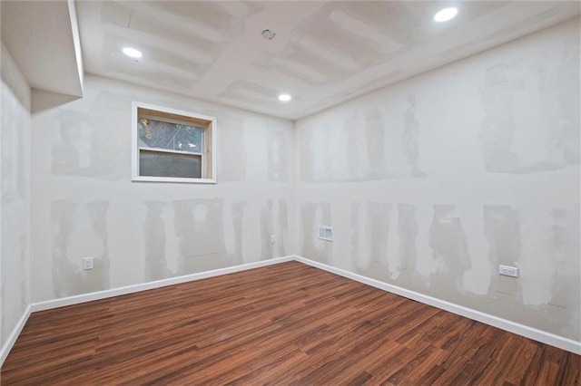 spare room featuring recessed lighting, wood finished floors, and baseboards