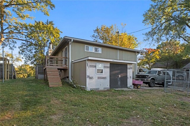 exterior space featuring a deck, a yard, stairway, and fence