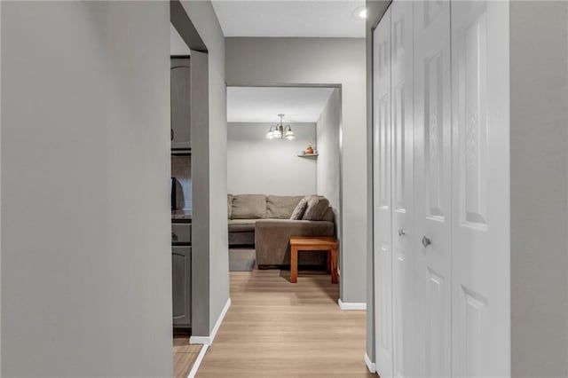 corridor with light wood finished floors and baseboards