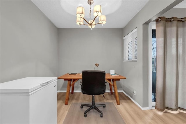 office area featuring a chandelier, light wood-style flooring, and baseboards