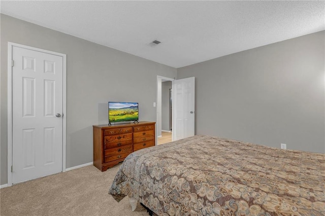 bedroom featuring light carpet, a textured ceiling, visible vents, and baseboards