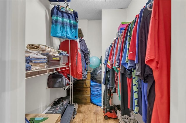 walk in closet with wood finished floors