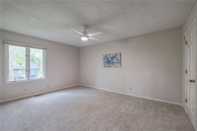 carpeted empty room with baseboards, ceiling fan, a textured ceiling, and visible vents