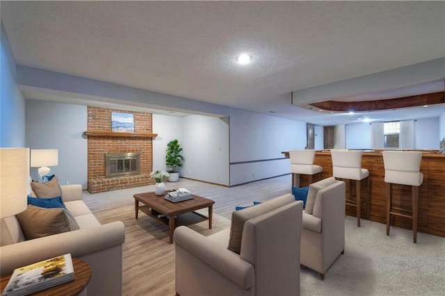 living area featuring a brick fireplace and a textured ceiling