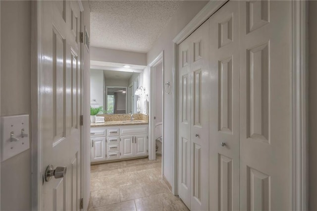 12016 Ballentine St, Overland Park, KS 66213 - bathroom featuring vanity, toilet, a textured ceiling, and tile patterned floors