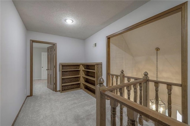 12016 Ballentine St, Overland Park, KS 66213 - corridor featuring a textured ceiling, carpet floors, an upstairs landing, and baseboards