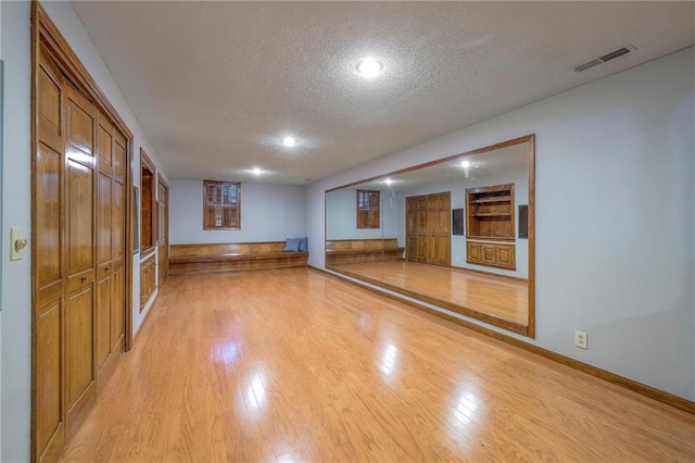 12016 Ballentine St, Overland Park, KS 66213 - unfurnished living room with a textured ceiling, light wood-type flooring, baseboards, and recessed lighting