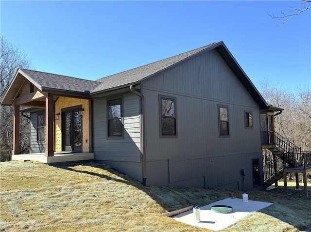 view of property exterior featuring a porch and roof with shingles