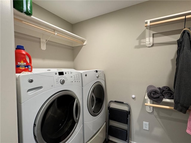 laundry room with heating unit, laundry area, and washer and dryer