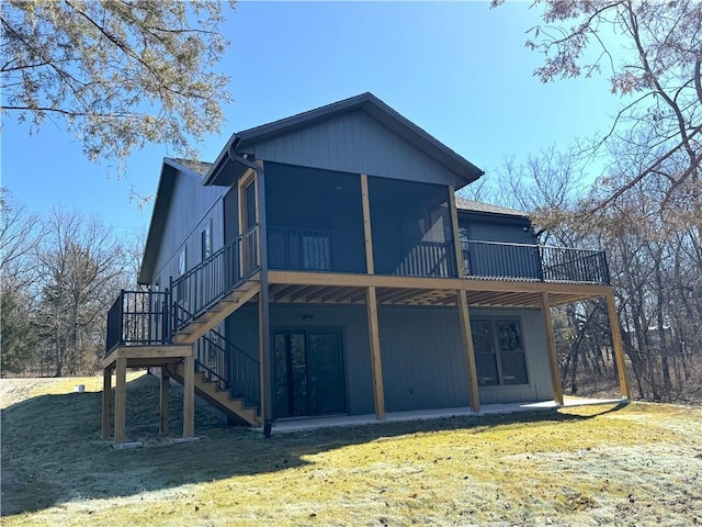 back of property with stairway, a yard, a deck, and a sunroom