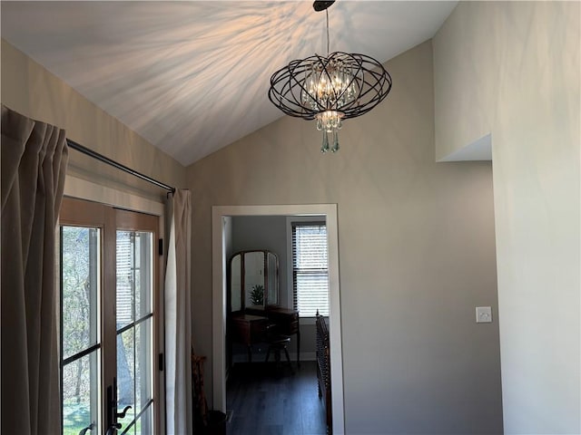 interior space featuring vaulted ceiling, dark wood-style floors, a healthy amount of sunlight, and a chandelier