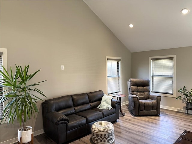 living room featuring recessed lighting, wood finished floors, baseboards, and high vaulted ceiling