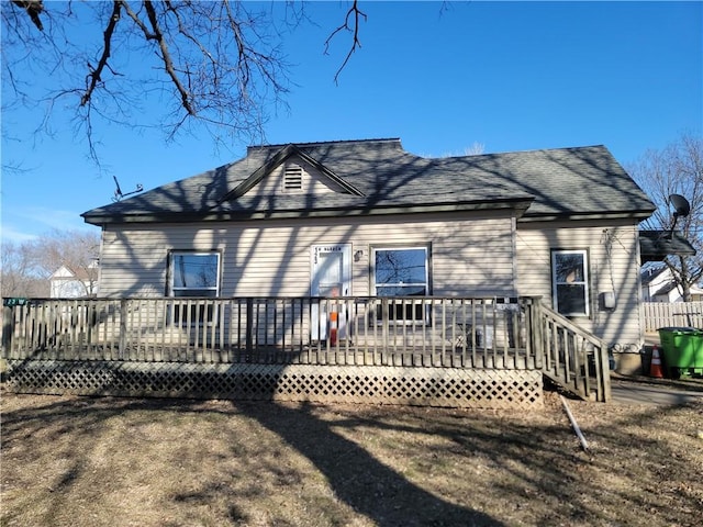 rear view of house with a shingled roof and a deck