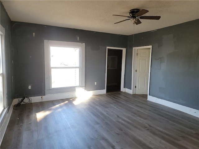 empty room featuring a ceiling fan, a textured ceiling, baseboards, and wood finished floors