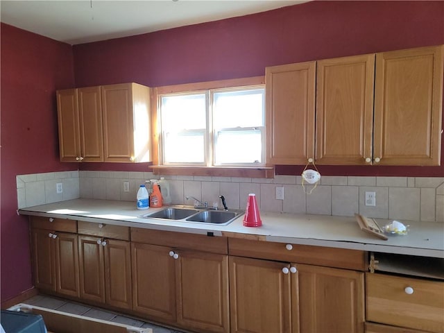 kitchen with backsplash, a sink, and light countertops