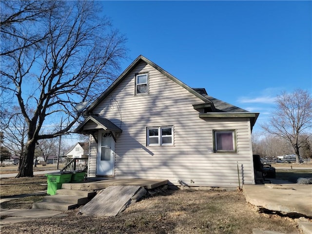 rear view of house featuring roof with shingles