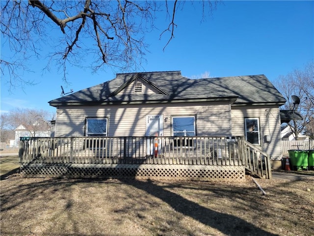 back of property featuring a shingled roof and a wooden deck