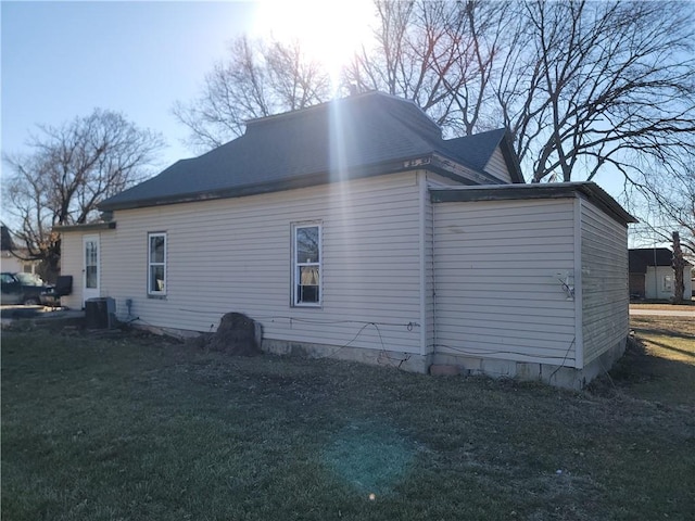 view of home's exterior with cooling unit and a yard