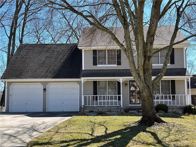 traditional-style house featuring covered porch, roof with shingles, and an attached garage