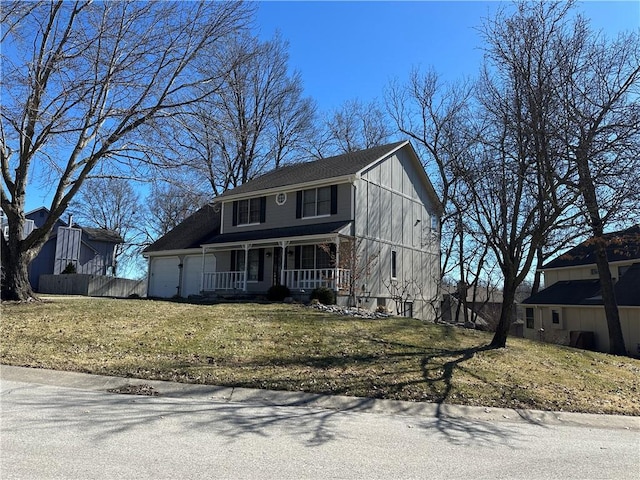 view of front of house with covered porch, a front lawn, fence, and a garage