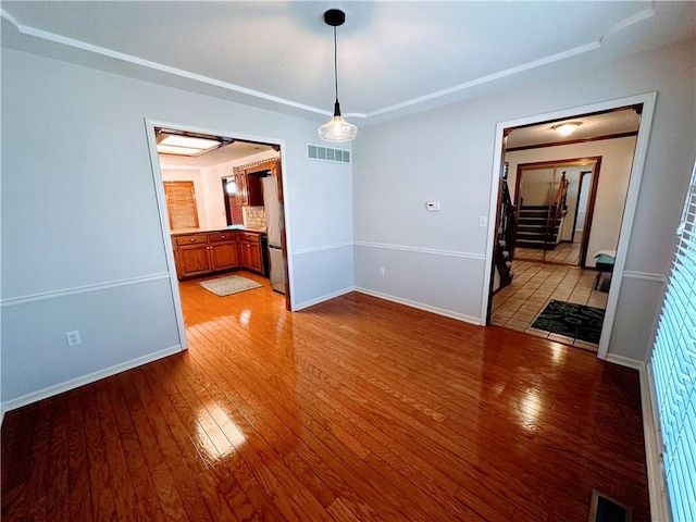 unfurnished dining area with light wood-style floors, baseboards, and visible vents