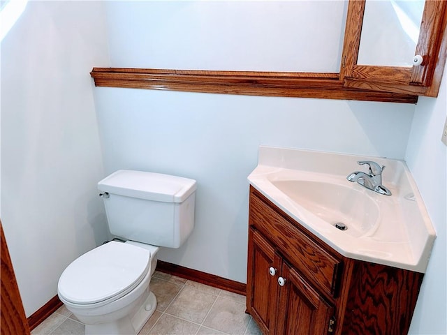 bathroom featuring tile patterned flooring, baseboards, vanity, and toilet