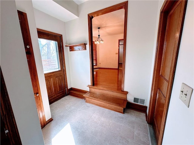 interior space featuring a chandelier, visible vents, and baseboards