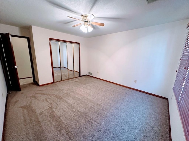 unfurnished bedroom with light carpet, visible vents, baseboards, ceiling fan, and a closet