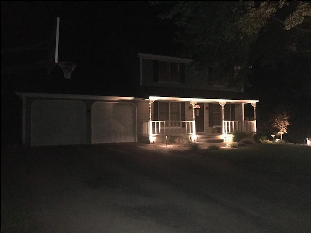 view of front of house featuring a garage, driveway, and a porch