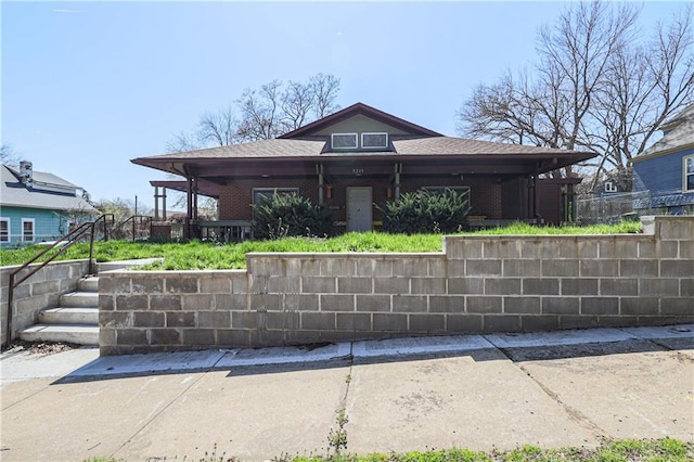 view of front facade featuring brick siding and fence