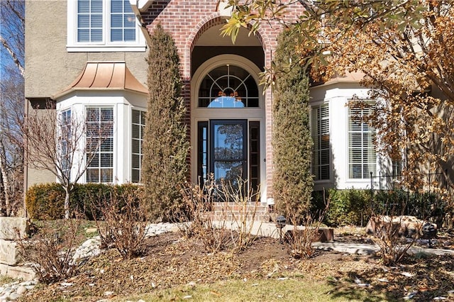 entrance to property with stucco siding and brick siding