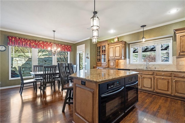 kitchen featuring dark wood-style floors, brown cabinets, oven, and decorative backsplash