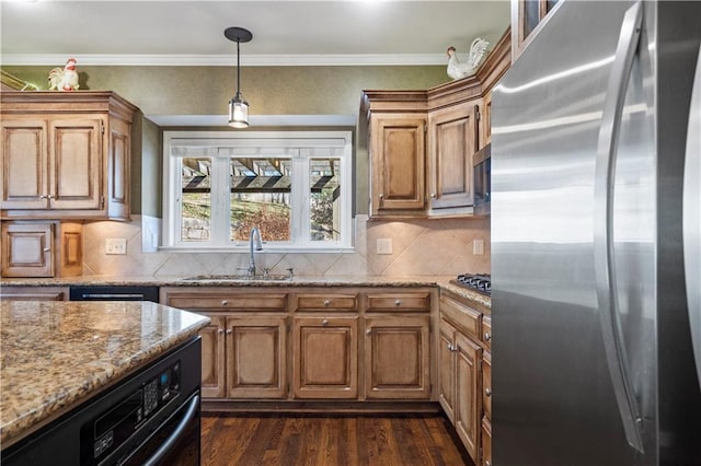 kitchen with dark wood finished floors, light stone countertops, stainless steel appliances, crown molding, and a sink