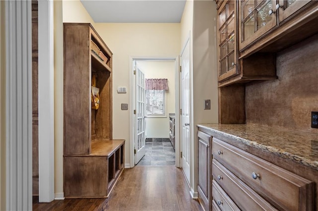 mudroom with dark wood-style floors and baseboards