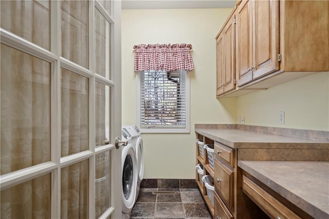 laundry area with stone finish flooring, cabinet space, and washer and dryer