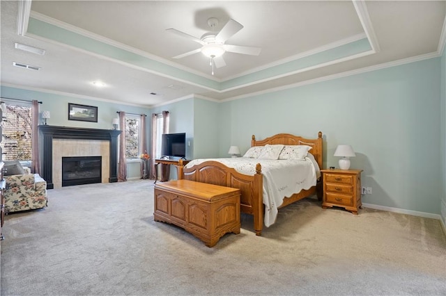 bedroom featuring crown molding, a fireplace, a raised ceiling, light colored carpet, and visible vents