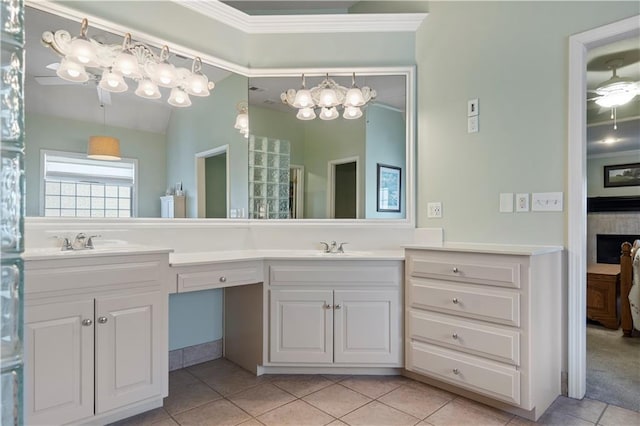 bathroom featuring crown molding, double vanity, lofted ceiling, a sink, and tile patterned flooring