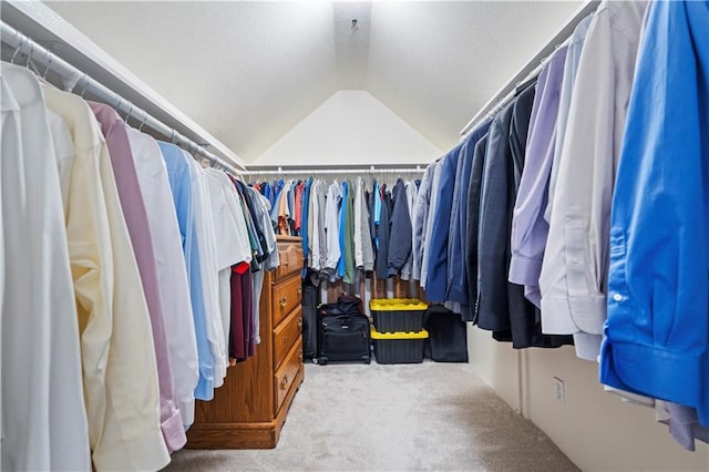 walk in closet featuring vaulted ceiling and carpet flooring