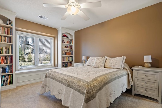 bedroom with ceiling fan, carpet, visible vents, and a decorative wall