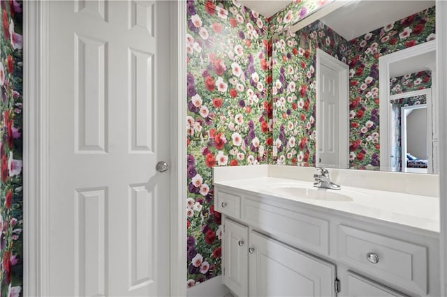 bathroom featuring vanity and wallpapered walls