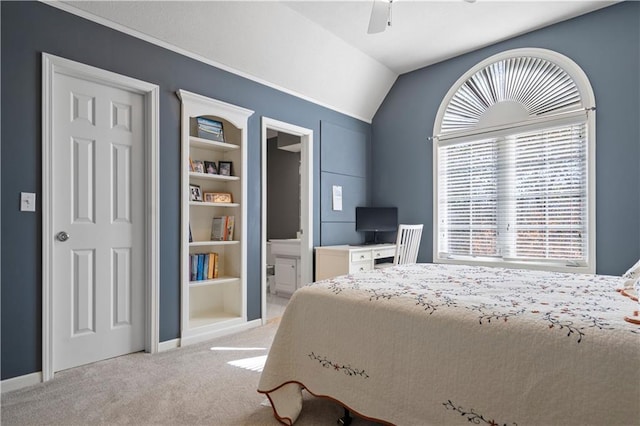 bedroom with lofted ceiling, ensuite bath, carpet, and a ceiling fan