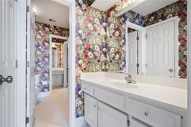 bathroom featuring wallpapered walls, visible vents, toilet, tile patterned floors, and vanity