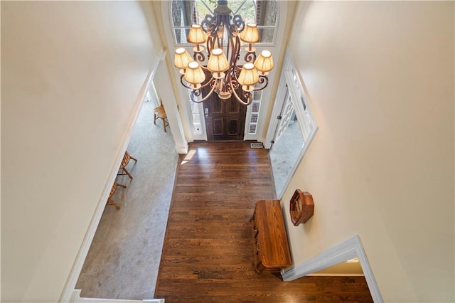 foyer entrance with baseboards, a notable chandelier, and wood finished floors