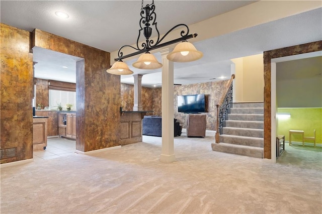 unfurnished dining area featuring carpet floors, decorative columns, stairs, and visible vents