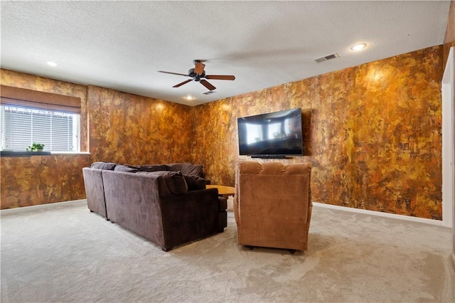 living room featuring a textured ceiling, ceiling fan, light colored carpet, visible vents, and baseboards