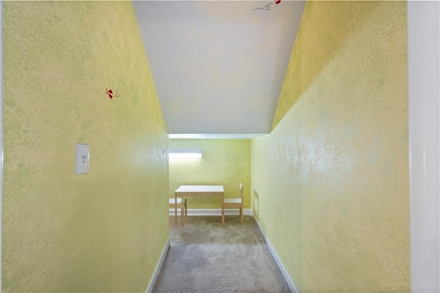 corridor with a textured wall, carpet flooring, and baseboards